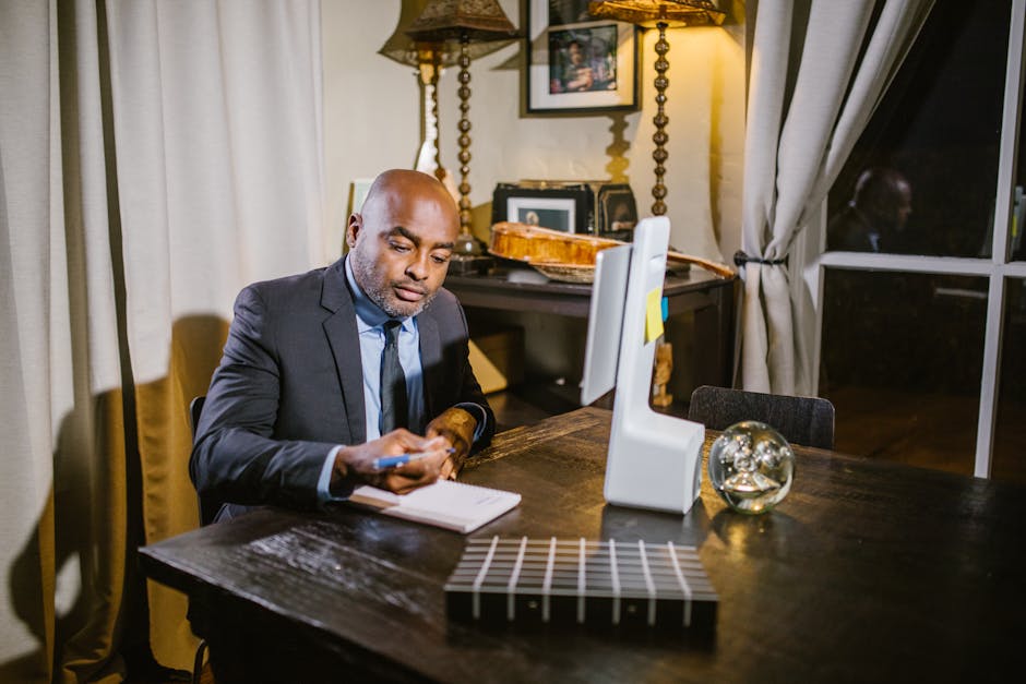 Professional businessman taking notes in a home office environment during the evening